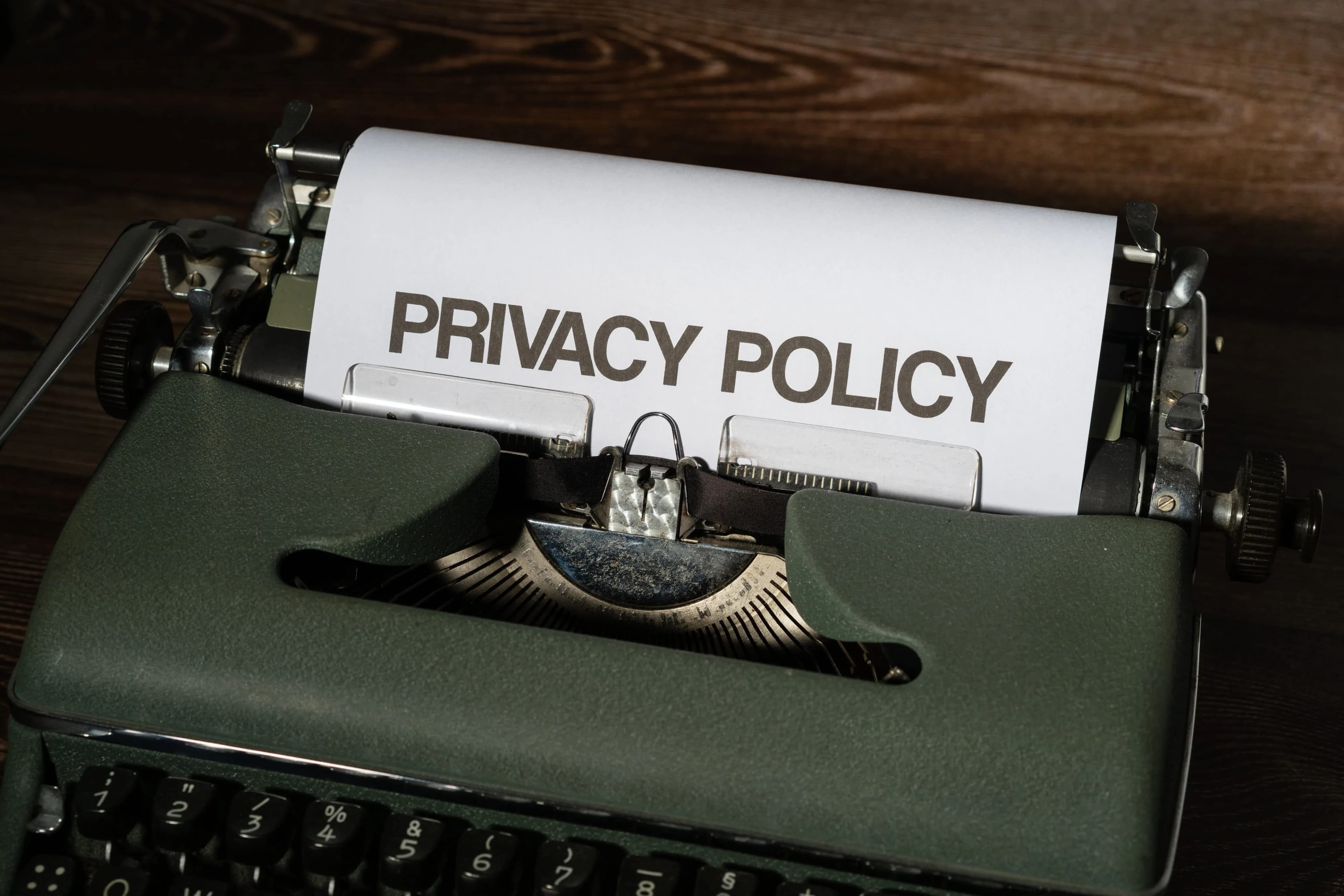 A vintage typewriter printing a sheet of paper that reads Privacy Policy